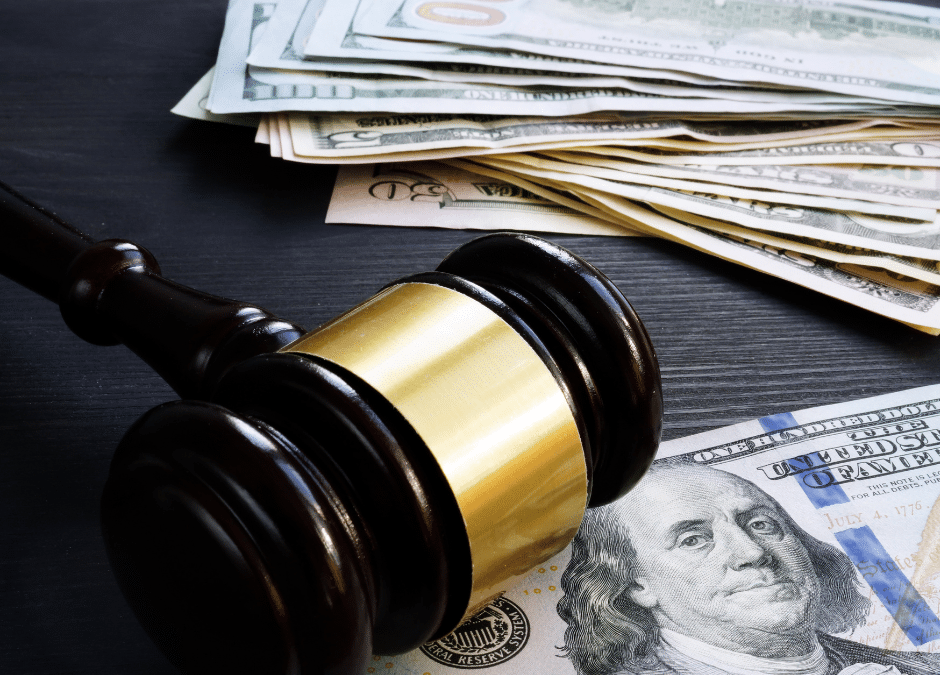 Wooden gavel resting on scattered hundred-dollar bills